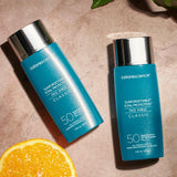 Colorescience Sunforgettable Total Protection Face Shield Classic SPF 50 2 bottles and an orange slice
